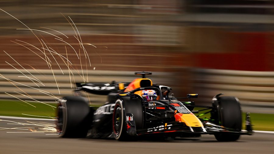 A Red Bull Racing Formula 1 car cornering at night, sparks streaming from under the chassis
