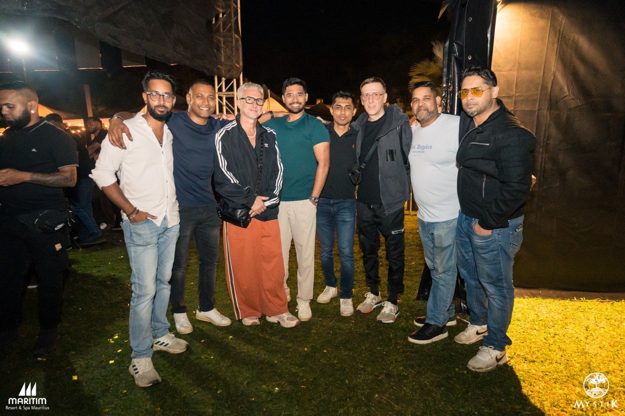 Event team and guests photographed on site at night in front of event tents and trussing